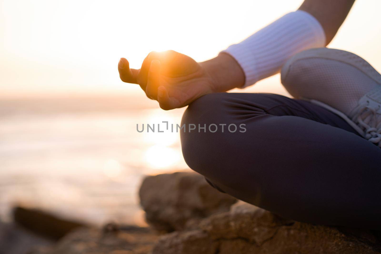 Woman practice yoga lotus pose to meditation with summer vacation rocky beach happiness and relaxation. Calm female exercise with yoga meditate ocean beach with sunset golden time. Zen Mental health