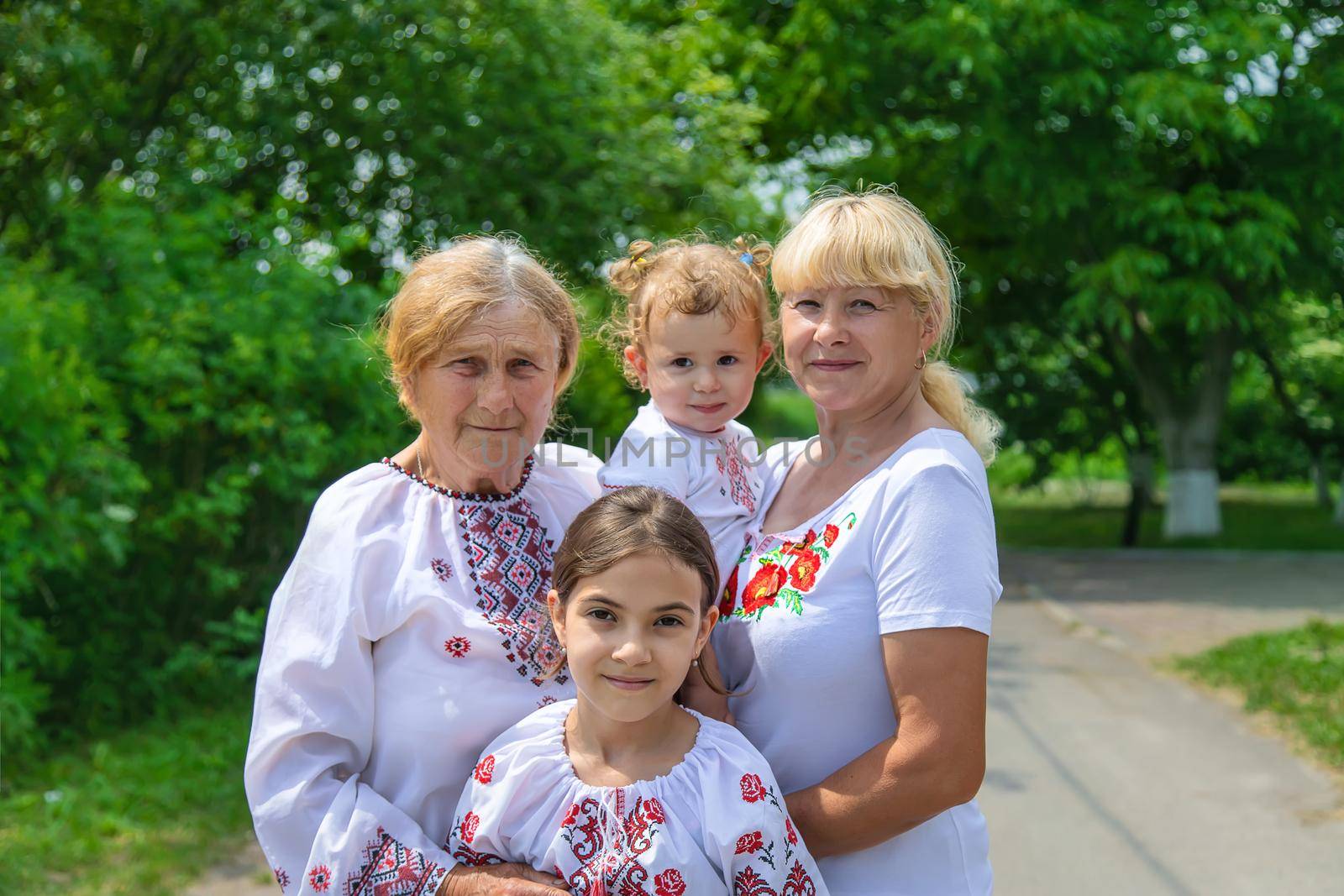 Family photo of a Ukrainian woman in embroidered shirts. Selective focus. Nature.