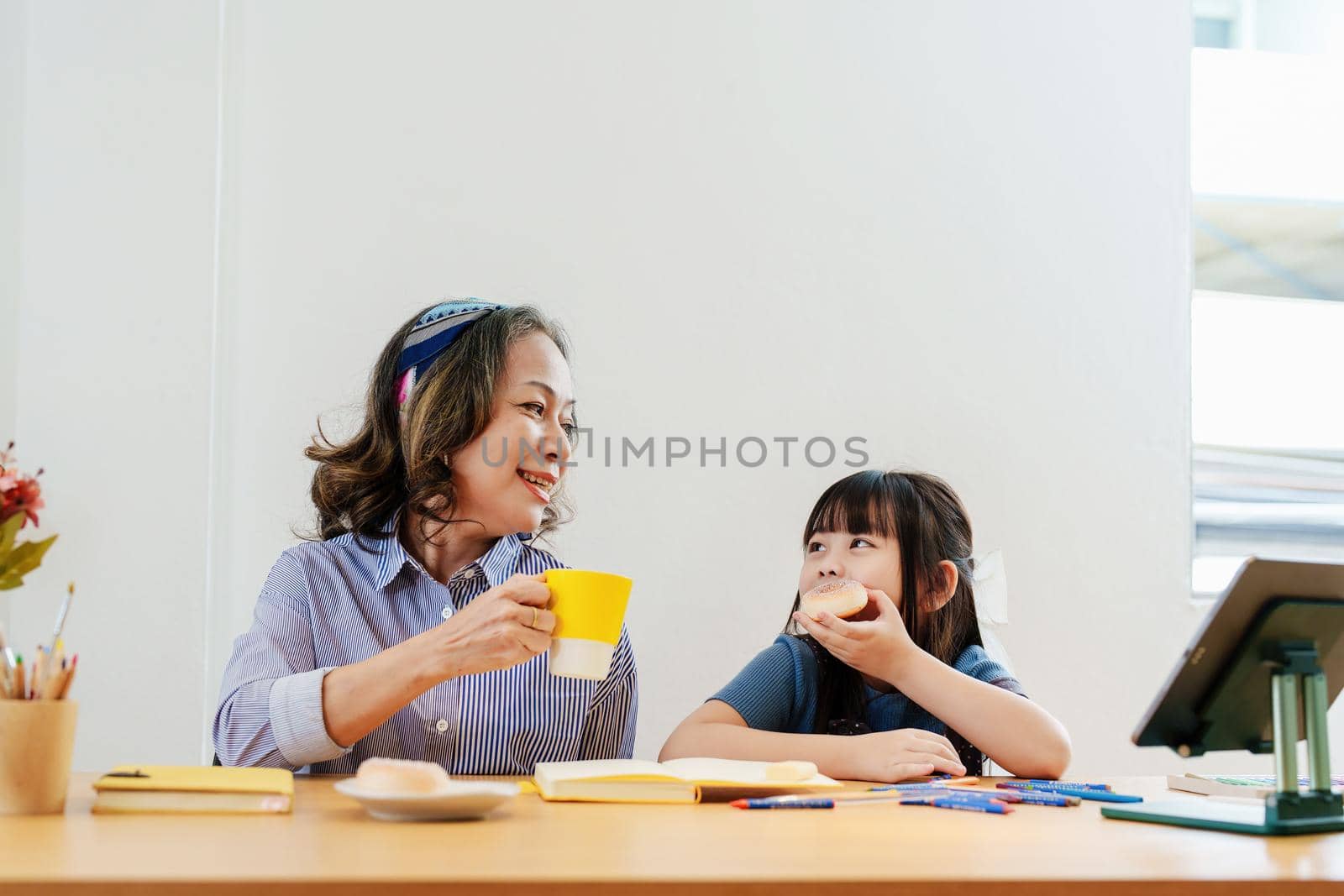 Asian portrait, grandchild granddaughter grandma grandmother and granddaughter happily join in activities to enjoy eating and enhance skills for grandchildren by Manastrong