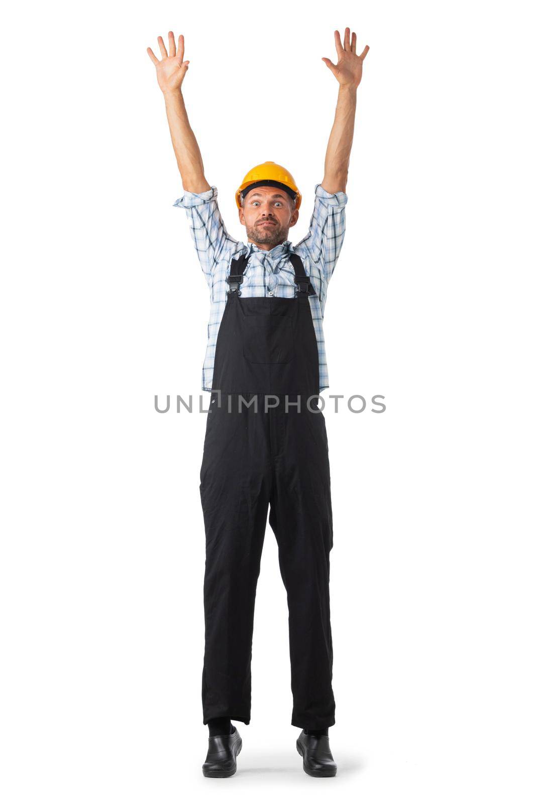 Portrait of confident male repairman contractor worker in coveralls and yellow hardhat standing with arms raised isolated on white background