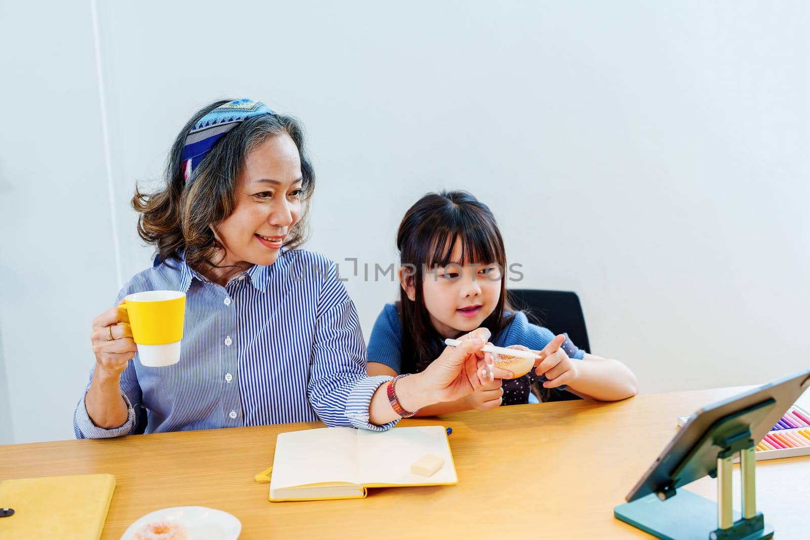 Asian portrait, grandchild granddaughter grandma grandmother and granddaughter happily join in activities to enjoy eating and enhance skills for grandchildren by Manastrong