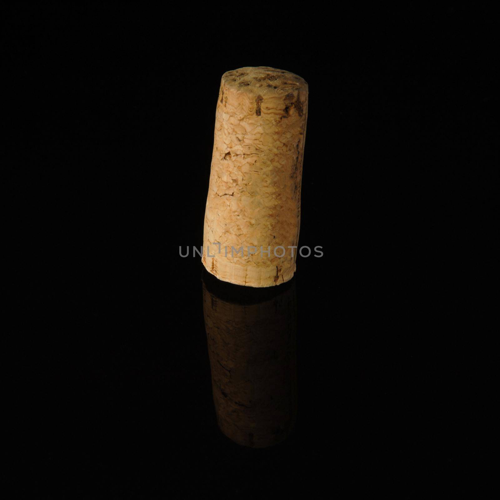 A close-up shot of a wine cork on a reflecting surface.