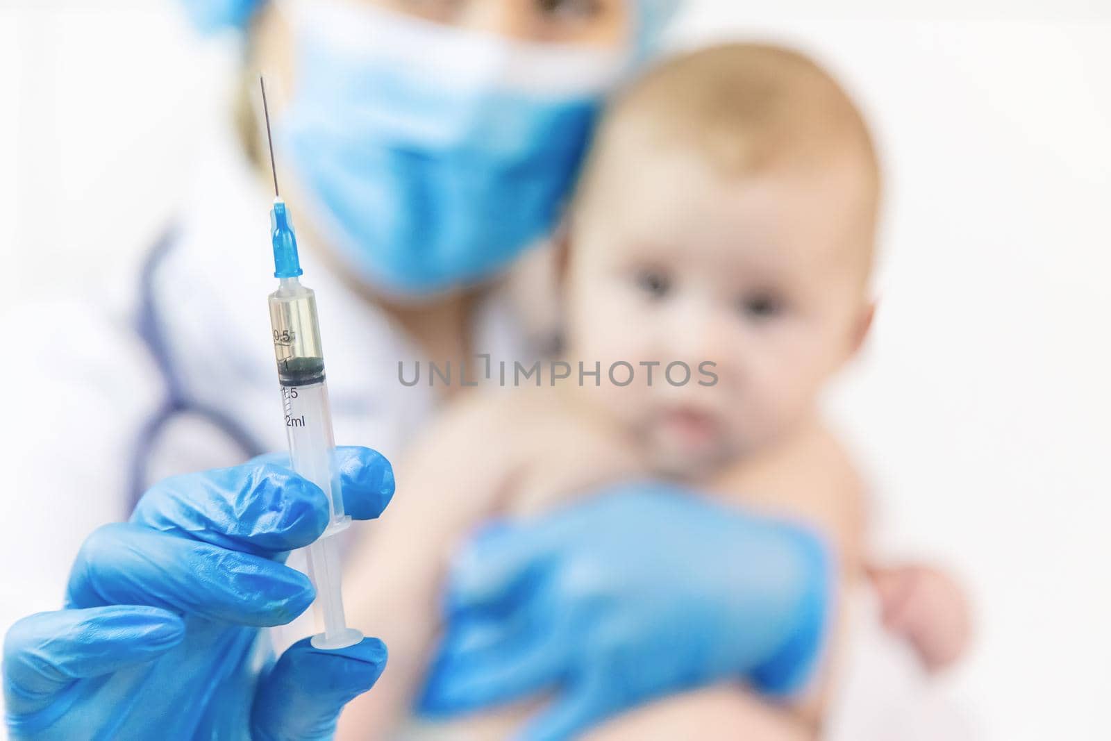 Vaccination of a baby by a doctor in a hospital. Selective focus. medicine.