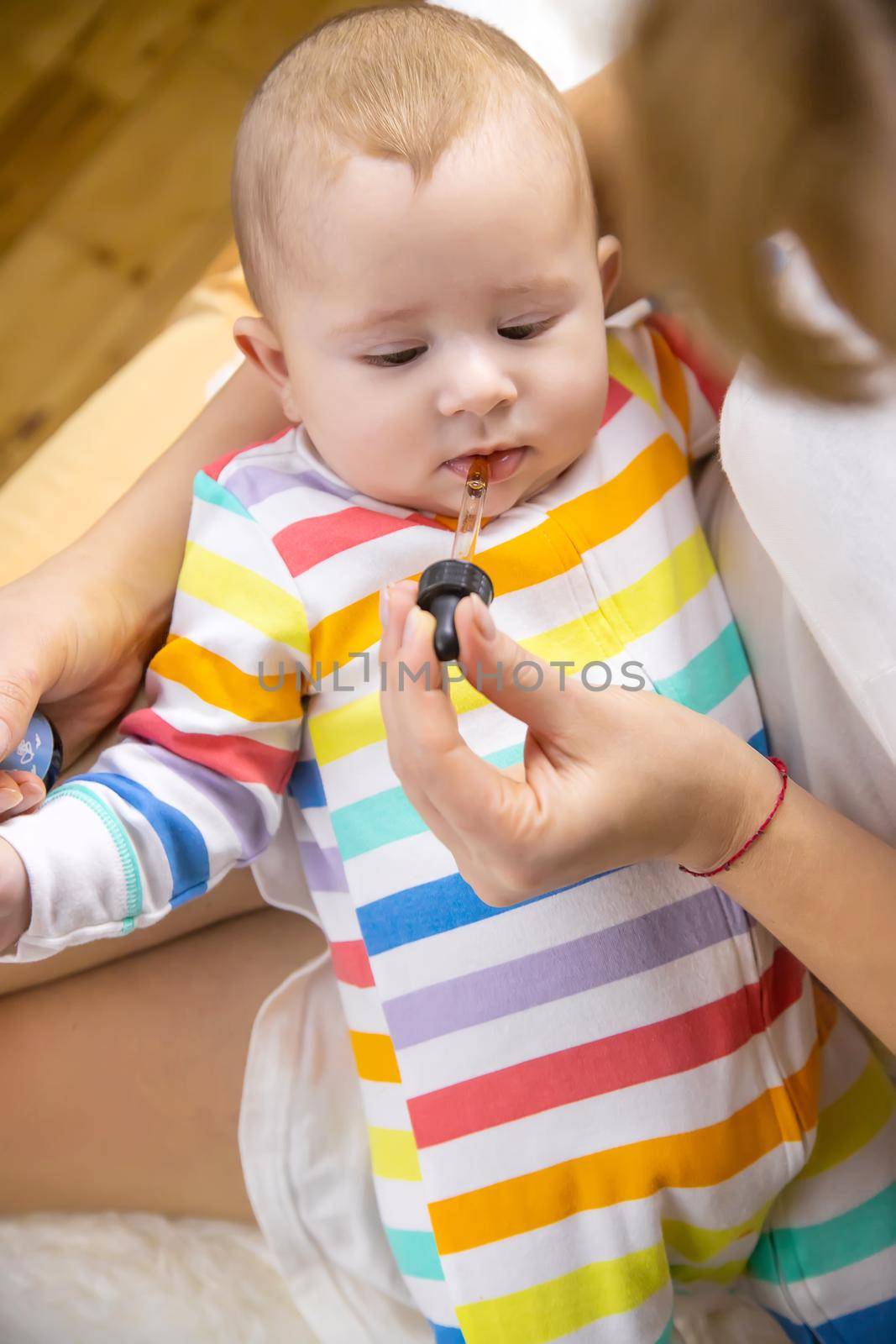 mother gives colic medicine to little baby. Selective focus. child.