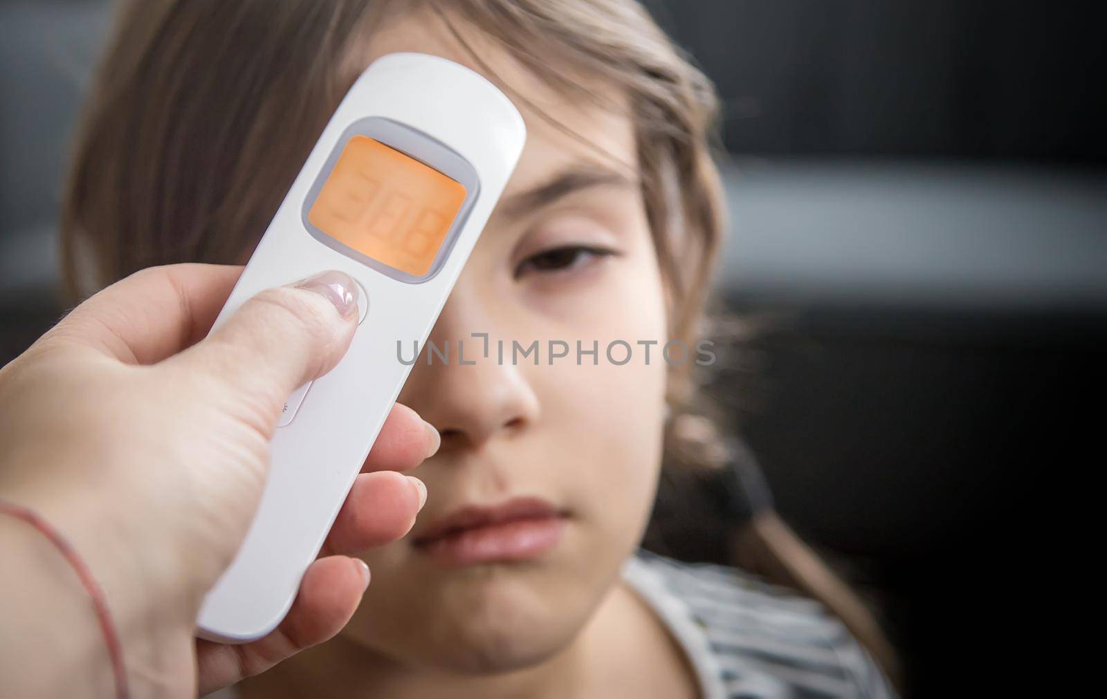 The mother measures the temperature of the child. Selective focus. People.