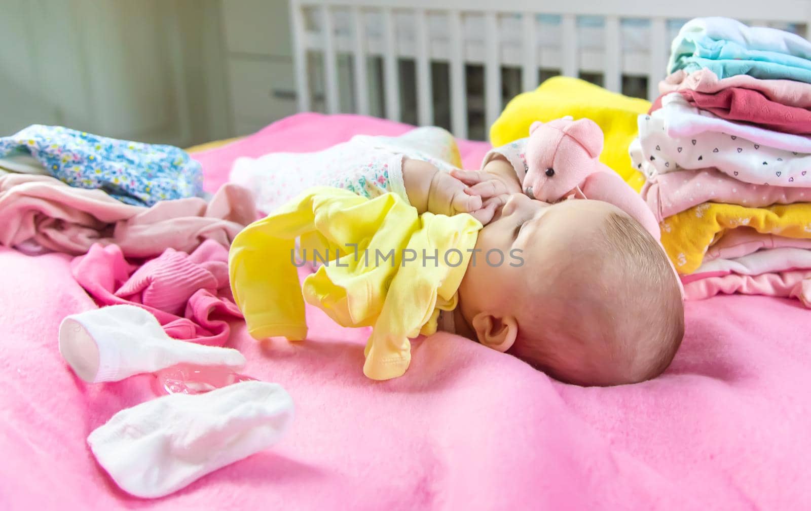 Baby scattered clothes and toys. Selective focus. people.