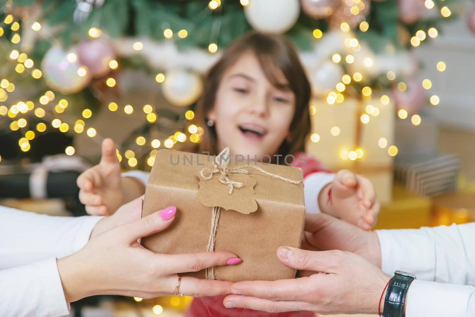 Child girl parents give presents for christmas. Selective focus. Holiday.