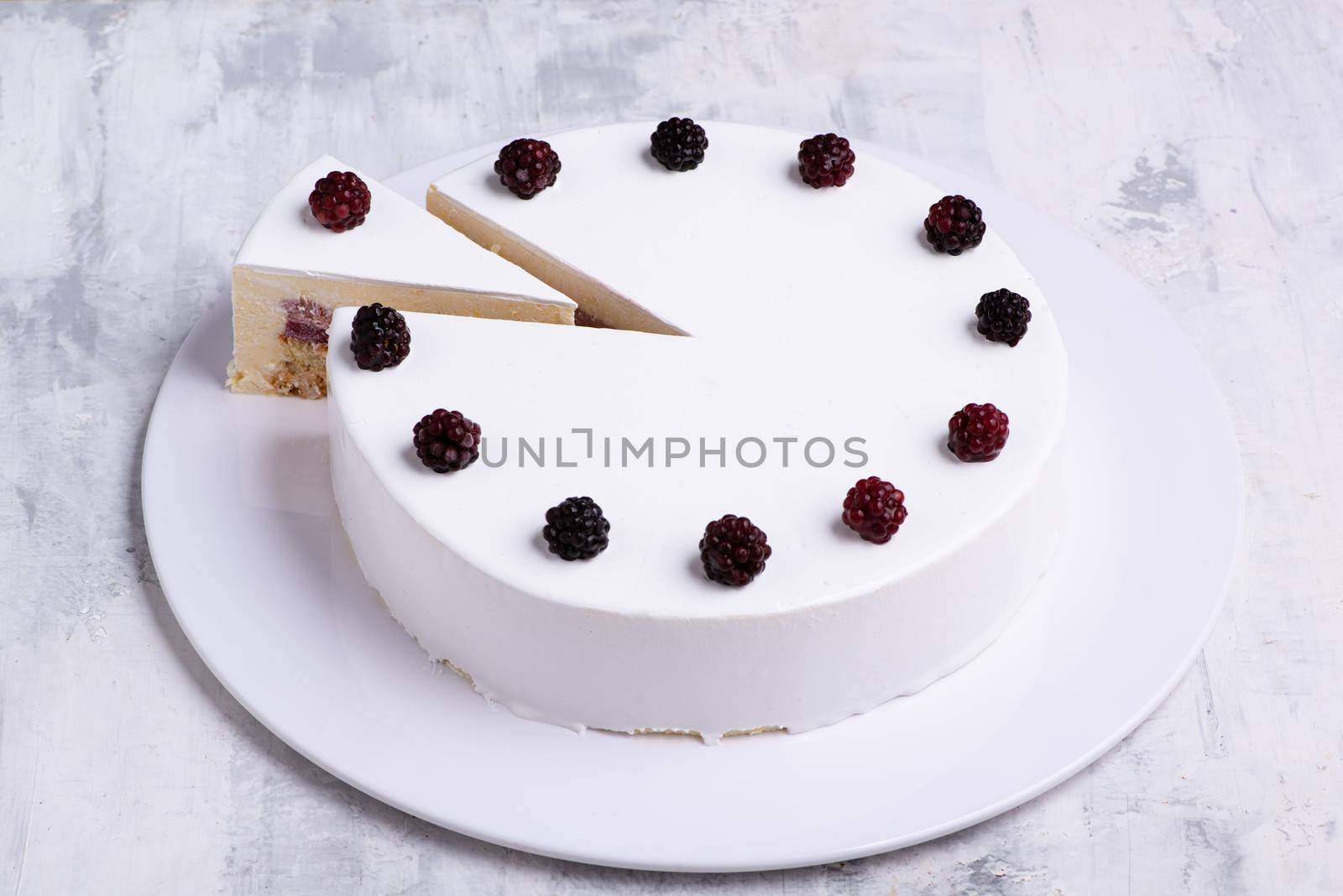 Closeup shot of white-layered cake topped with fresh berries by A_Karim