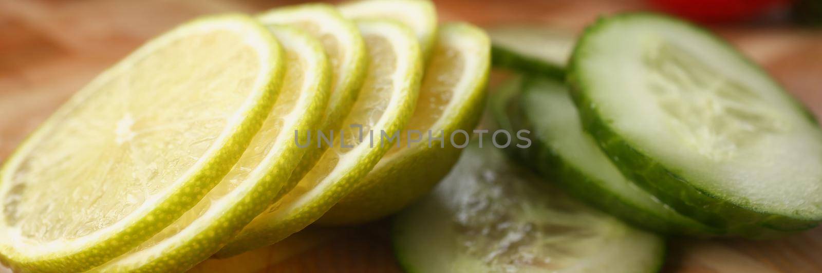 Close-up of fresh sliced cucumber and citrus lemon for further cooking. Try new recipe for dinner, cooking on kitchen. Food, chef, taste, gourmet concept