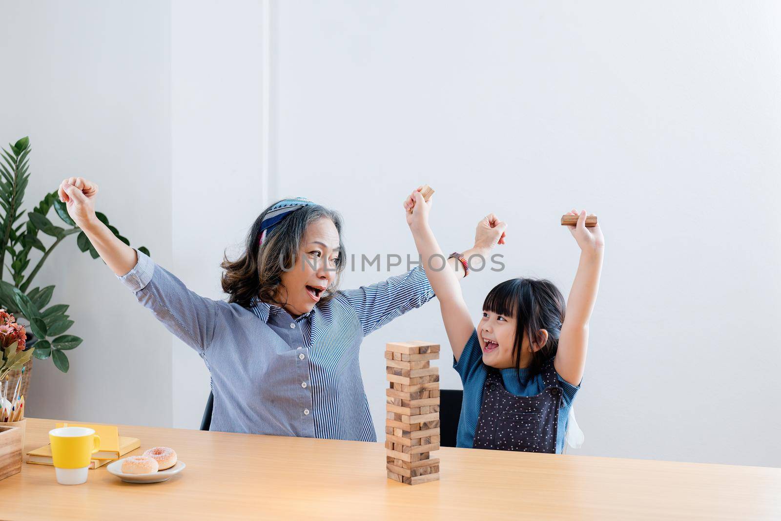 Asian portrait, grandchild granddaughter grandma grandmother and granddaughter happily join in activities to Block wood game Puzzle and enhance skills for grandchildren.