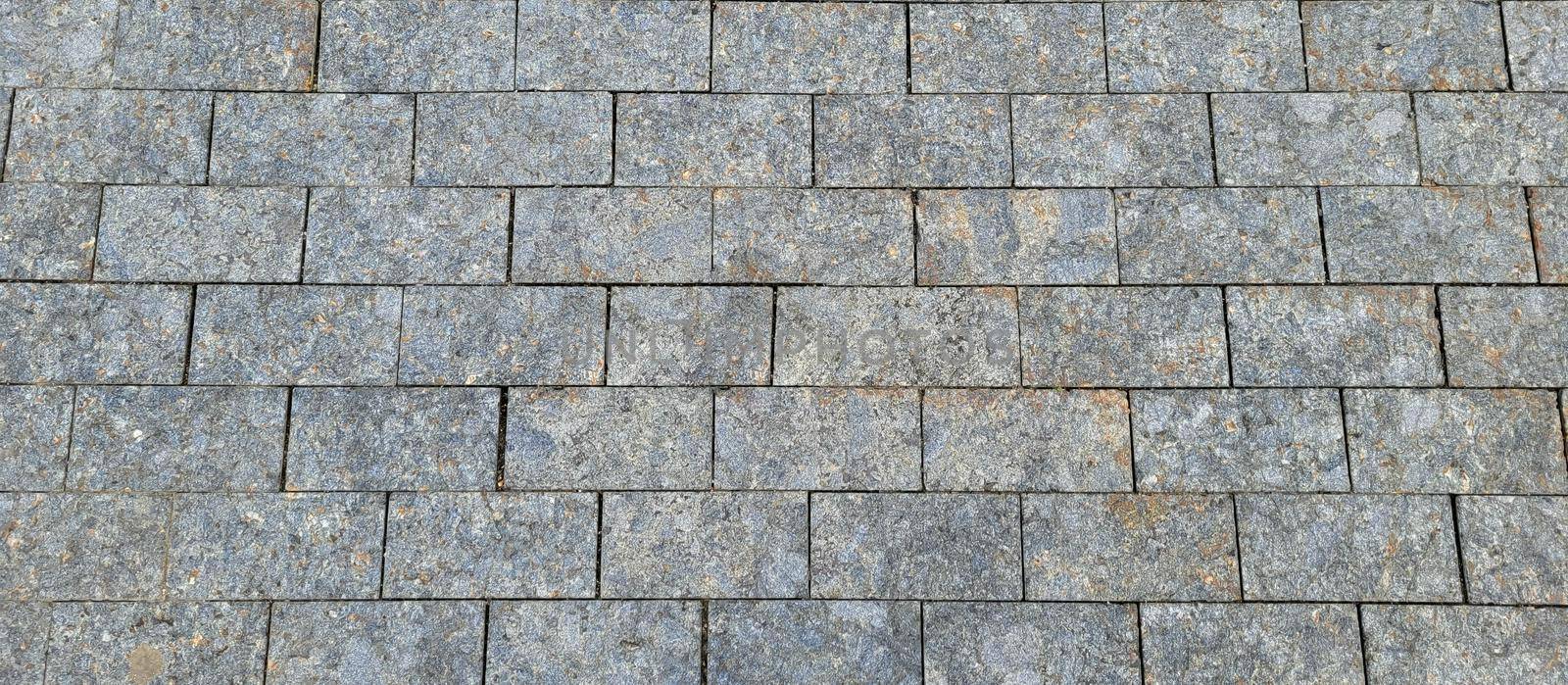 Texture of concrete pavement or sidewalk with paving slabs, top view. Blocks of the sidewalk pattern, details of the stone-tiled path