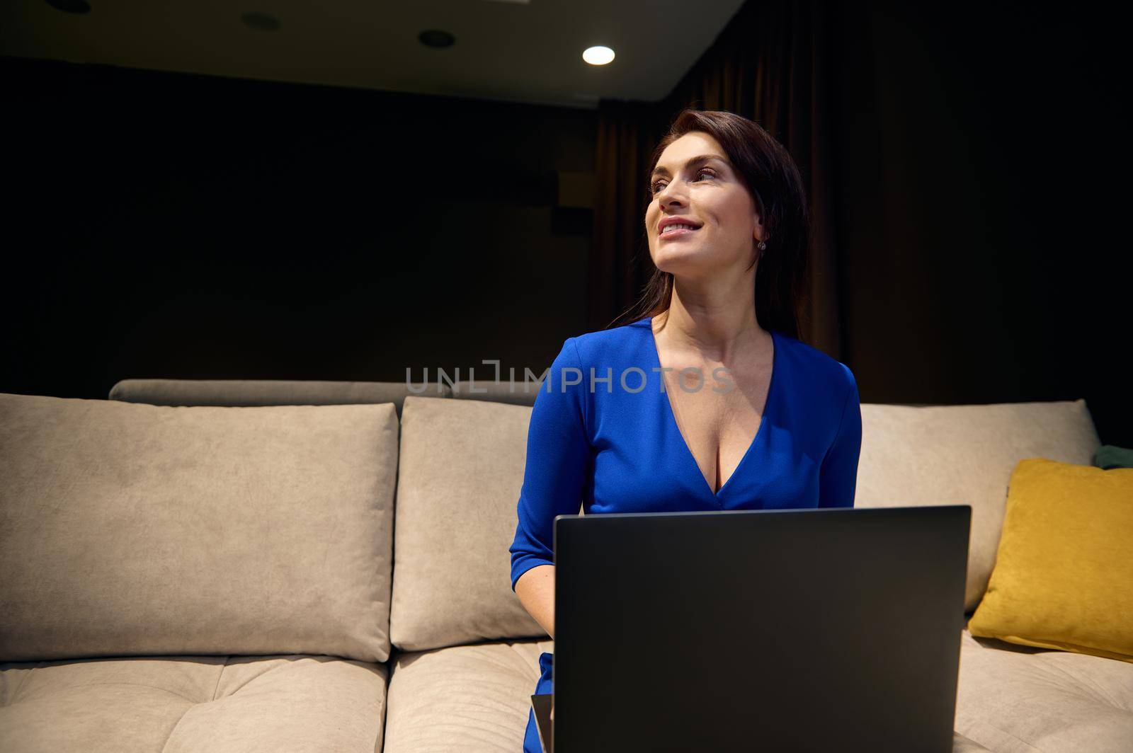 Attractive inspired young Caucasian woman- interior designer using laptop working on a housing project in an interior design studio. Business Woman, entrepreneur, real estate agent. Small business