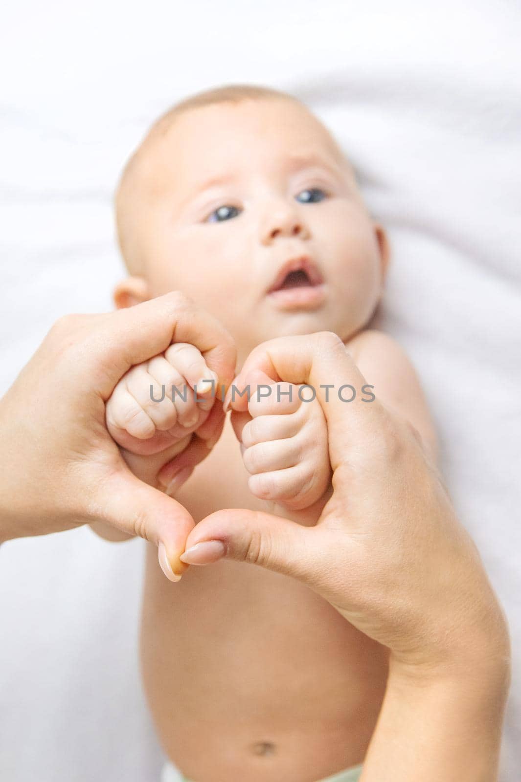 The mother holds the baby's hand. Selective focus. People.