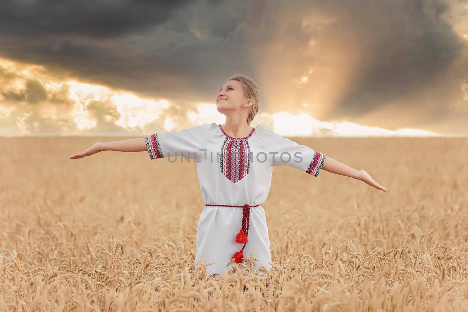 girl in Ukrainian national costume on a wheat field by zokov