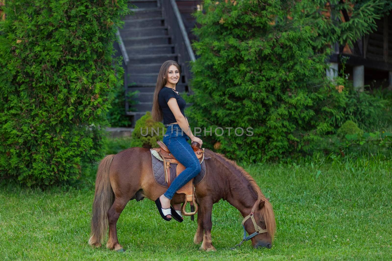 woman riding a pony on the lawn