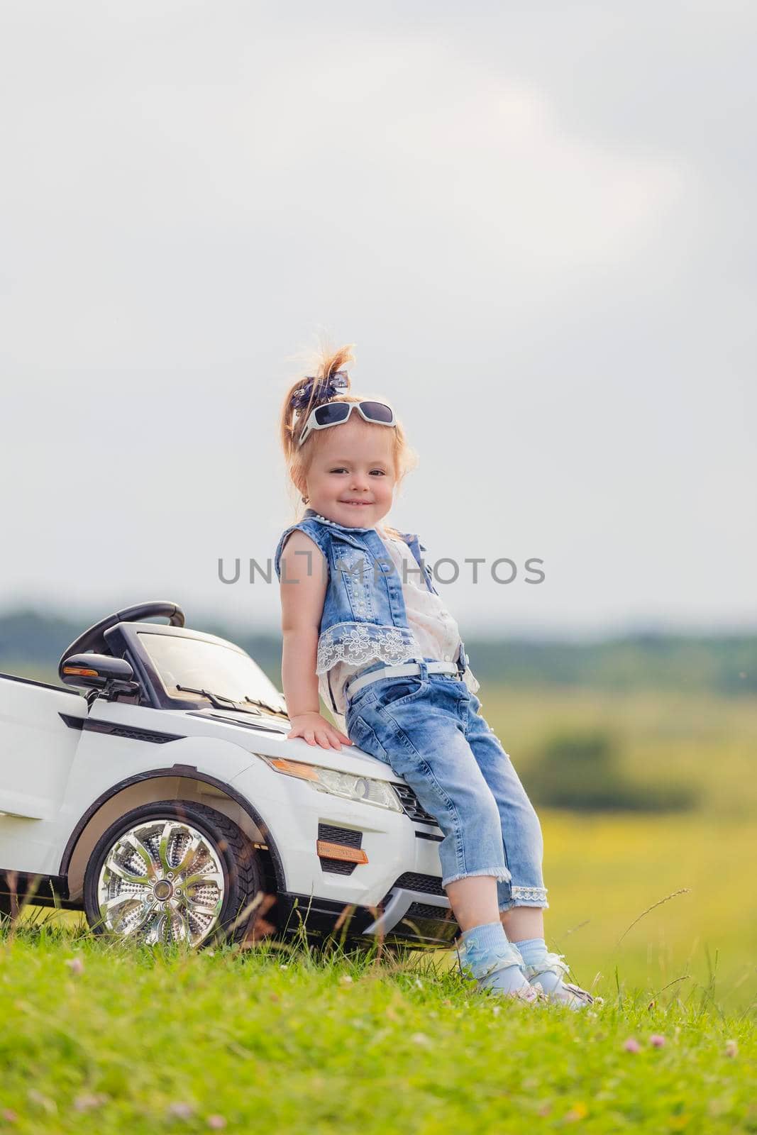 little girl standing near her baby car