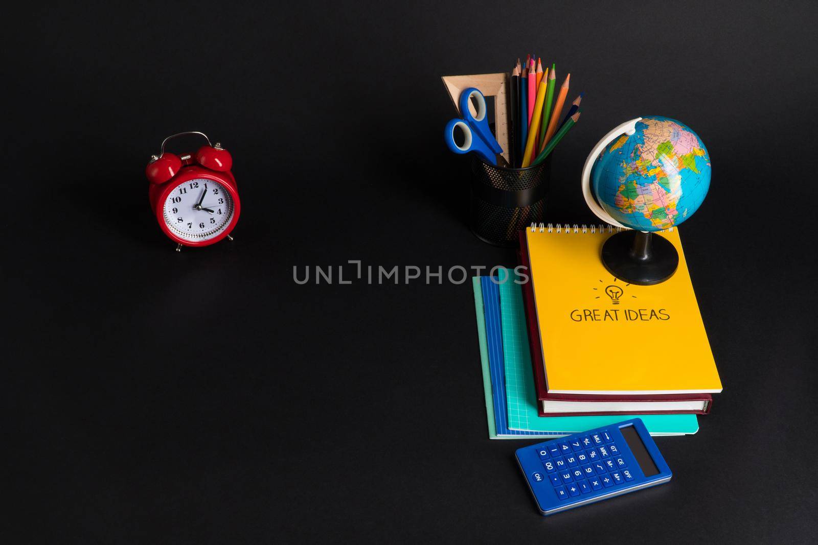 Some educational school supplies on a black background.