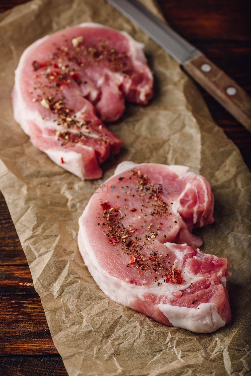 Pork loin steaks with ground spices on baking paper