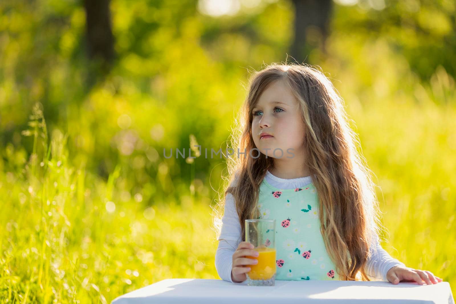 girl in nature with a glass of orange juice by zokov