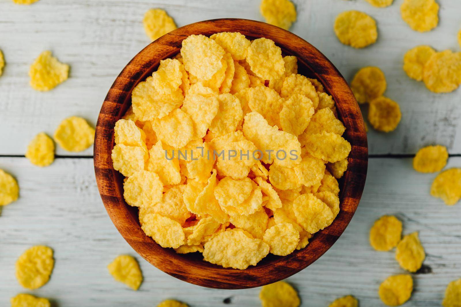 Rustic bowl of cornflakes over wooden surface. View from above