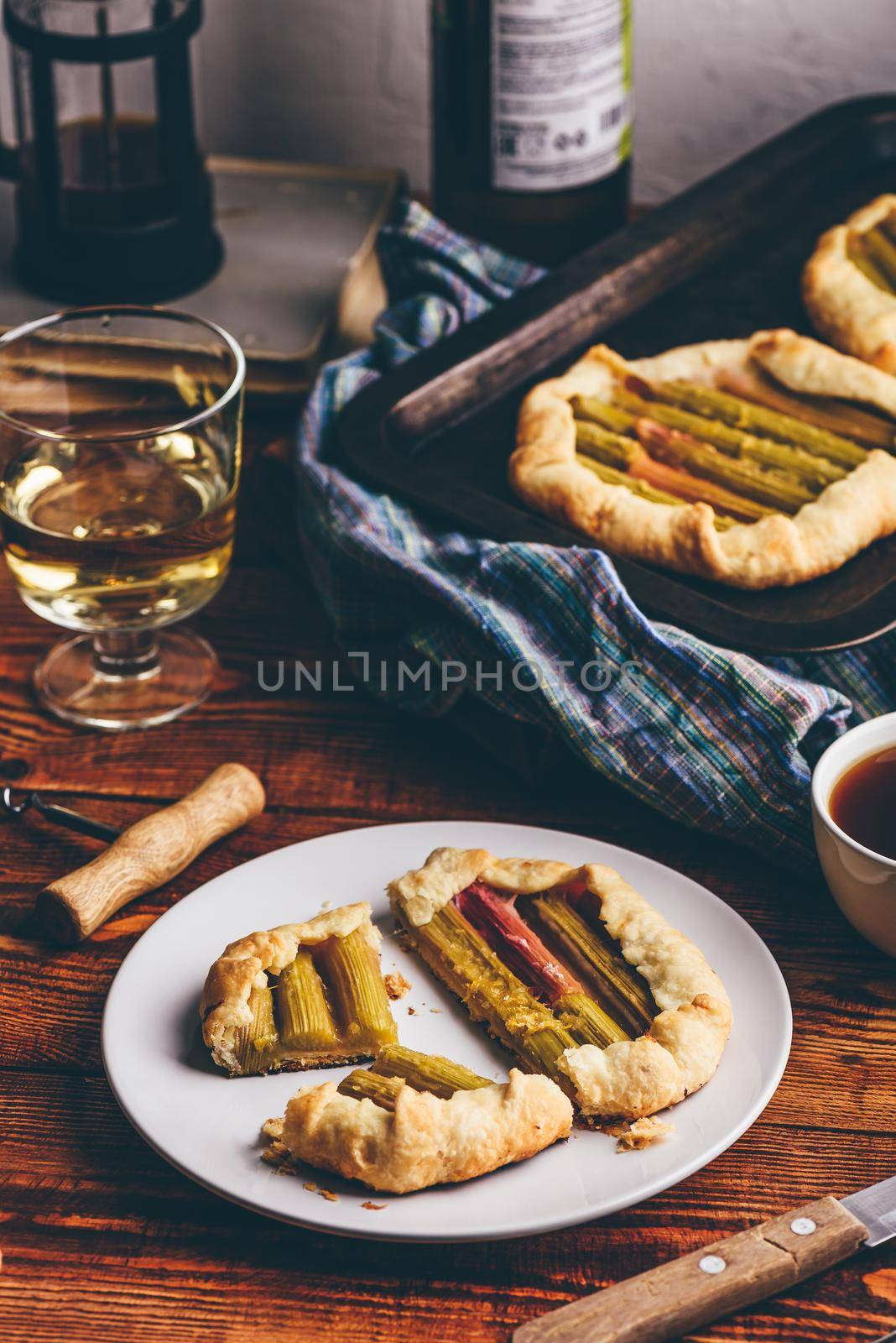 Rhubarb galette on plate with glass of wine by Seva_blsv