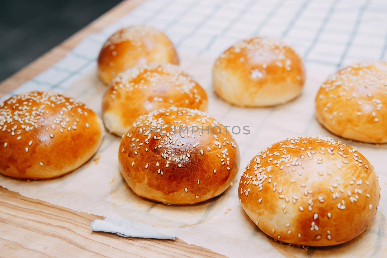 Freshly baked burger buns with sesame seeds. We cook at home.