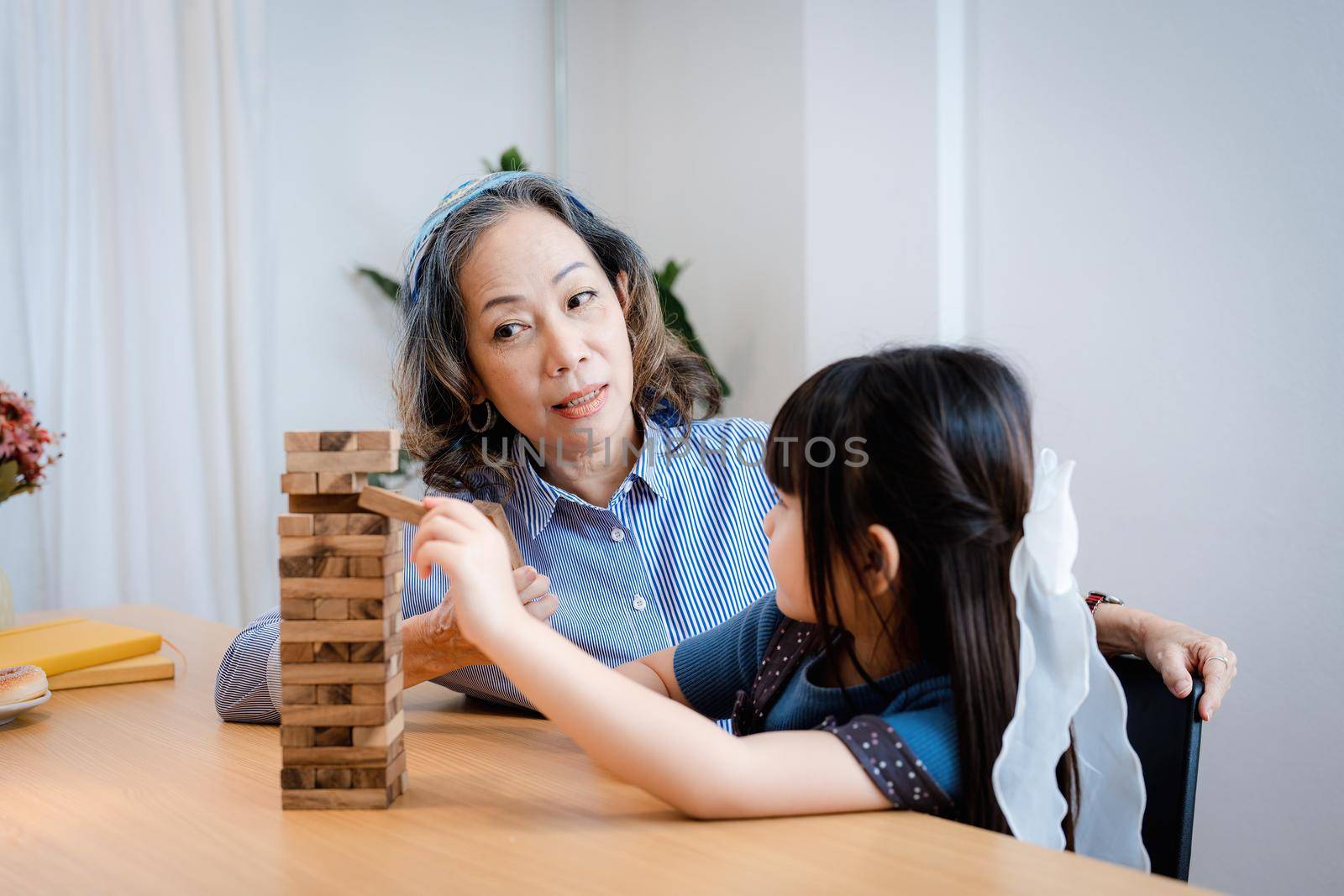 Asian portrait, grandchild granddaughter grandma grandmother and granddaughter happily join in activities to Block wood game Puzzle and enhance skills for grandchildren by Manastrong