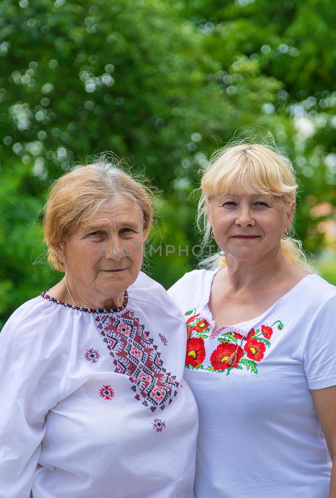 Family photo of a Ukrainian woman in embroidered shirts. Selective focus. Nature.