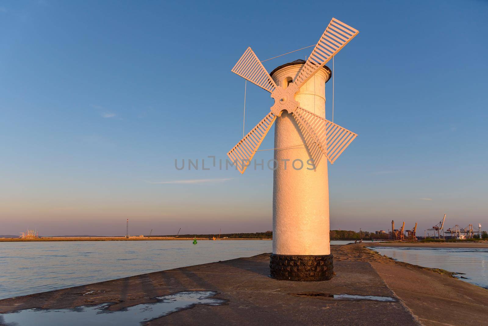 Stawa Mlyny, a beacon in the shape of a windmill as an official symbol of Swinoujscie at sunset