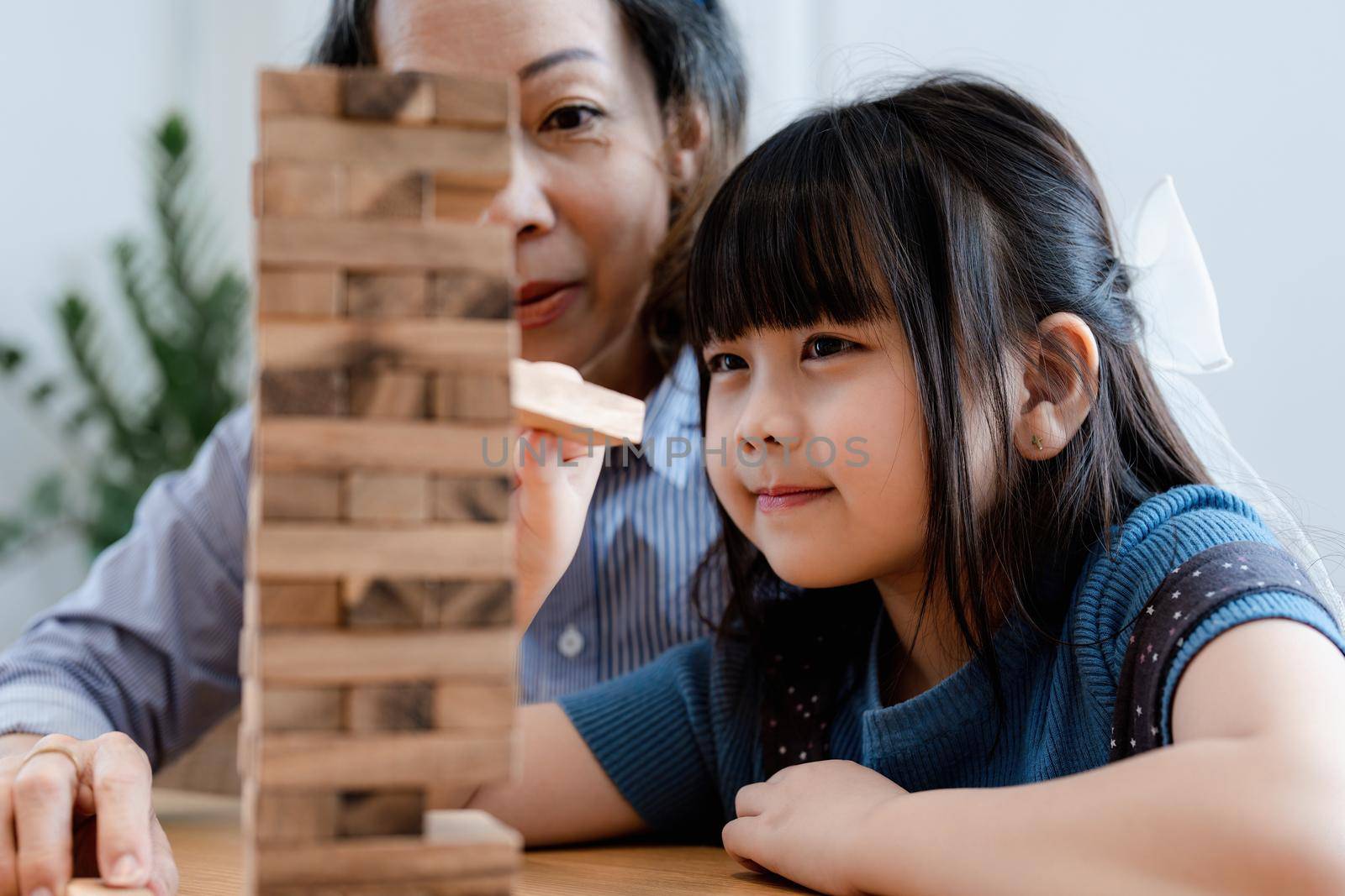 Asian portrait, grandchild granddaughter grandma grandmother and granddaughter happily join in activities to Block wood game Puzzle and enhance skills for grandchildren by Manastrong