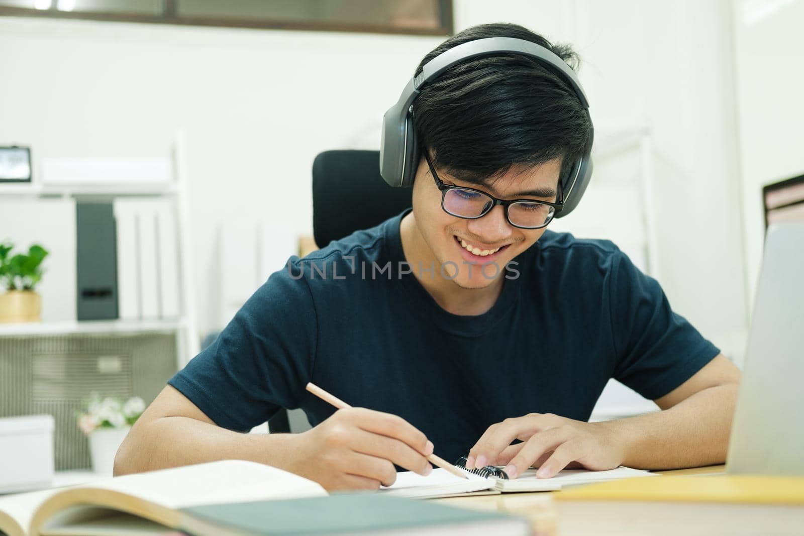 Young male student study at home. He using laptop and learning online.
