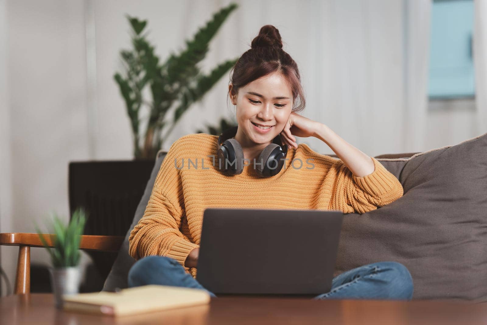 Portrait of Happy Asian artist woman using smart phone and listen music at home. Relax concept