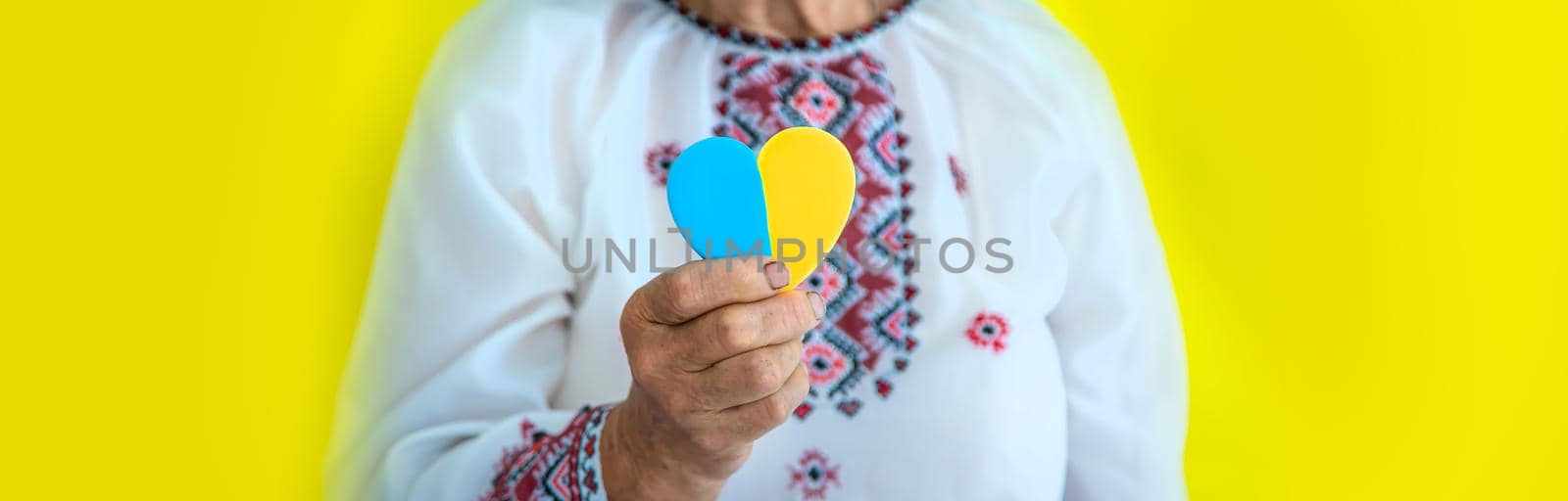 Grandmother is a Ukrainian patriot in an embroidered shirt. selective focus. by yanadjana
