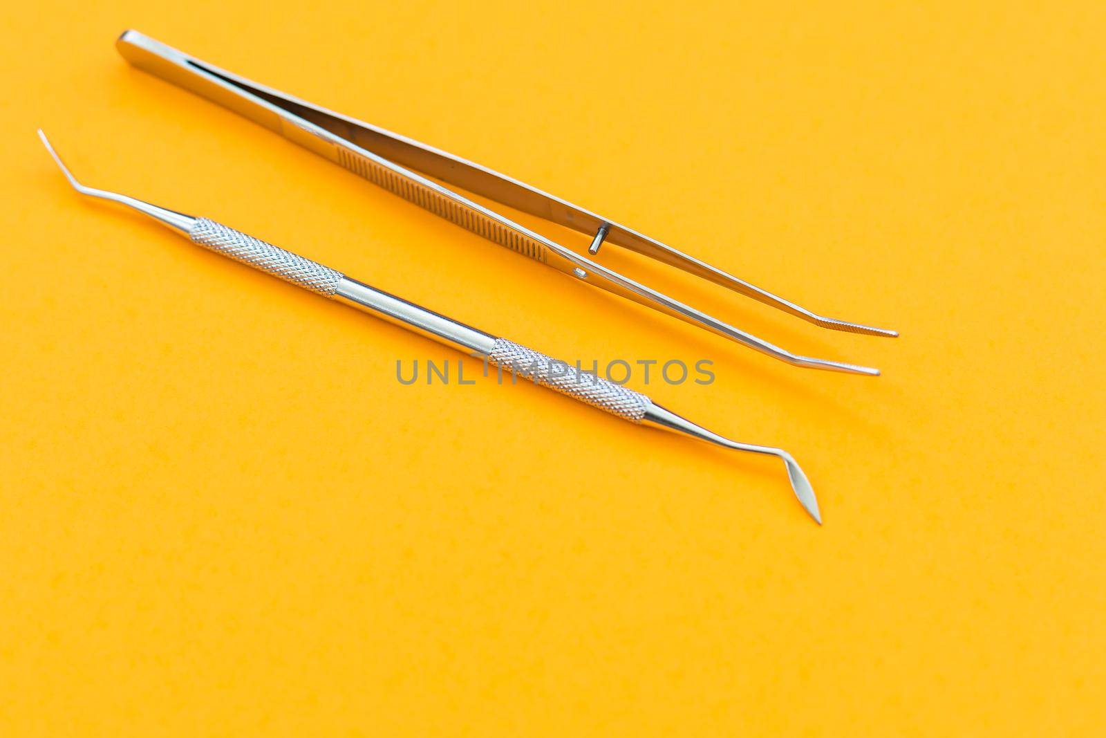 dental tool on an orange background.