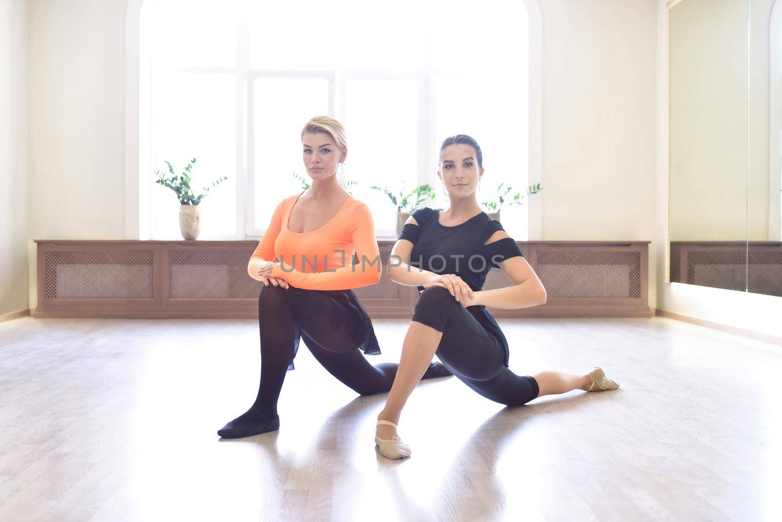 Female choreographer teacher mentor trainer of classical dance teaches posture help with stretching to young student learn dancing teen girl ballerina
