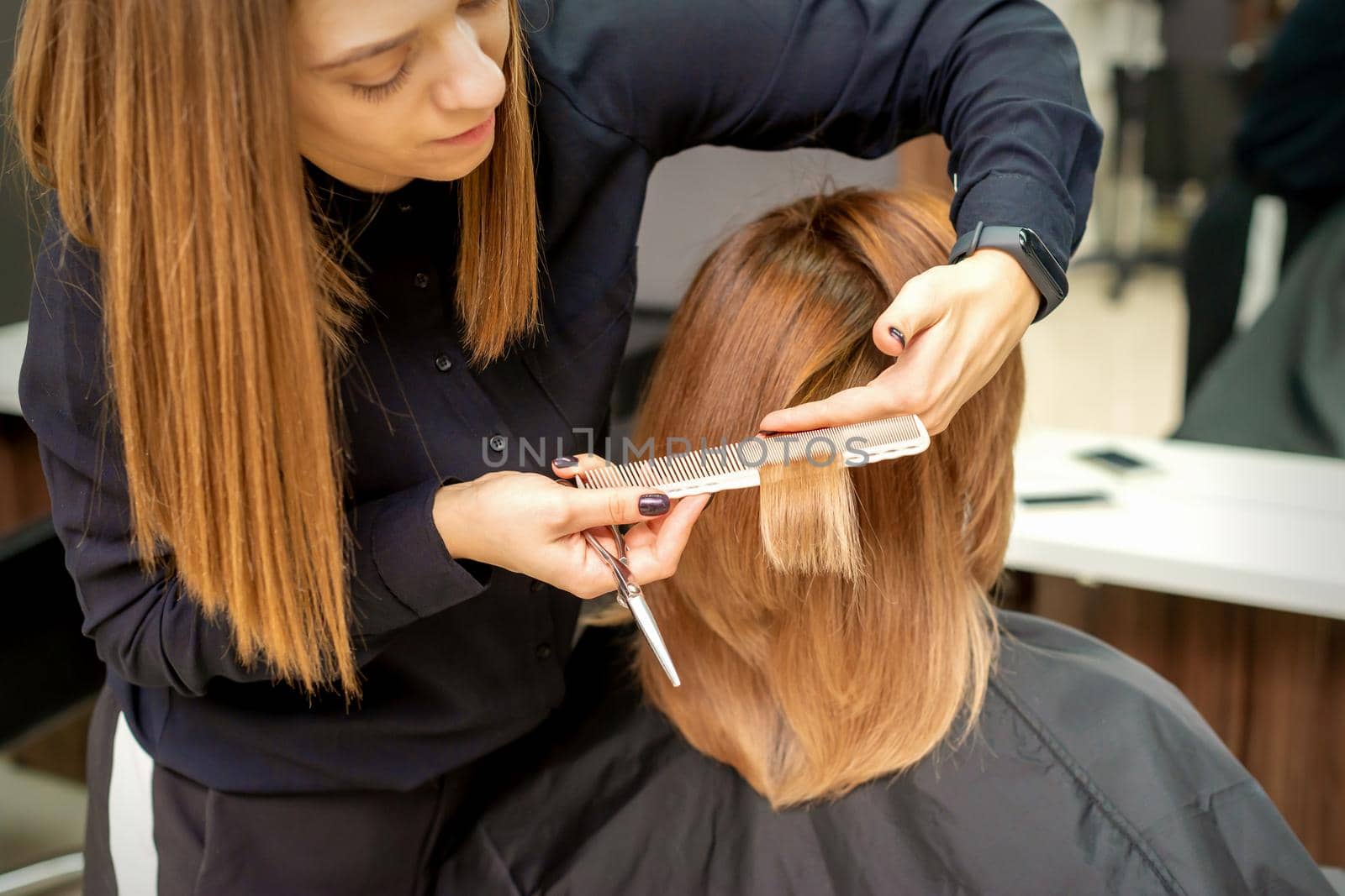 Hairdresser cuts hair to young woman by okskukuruza