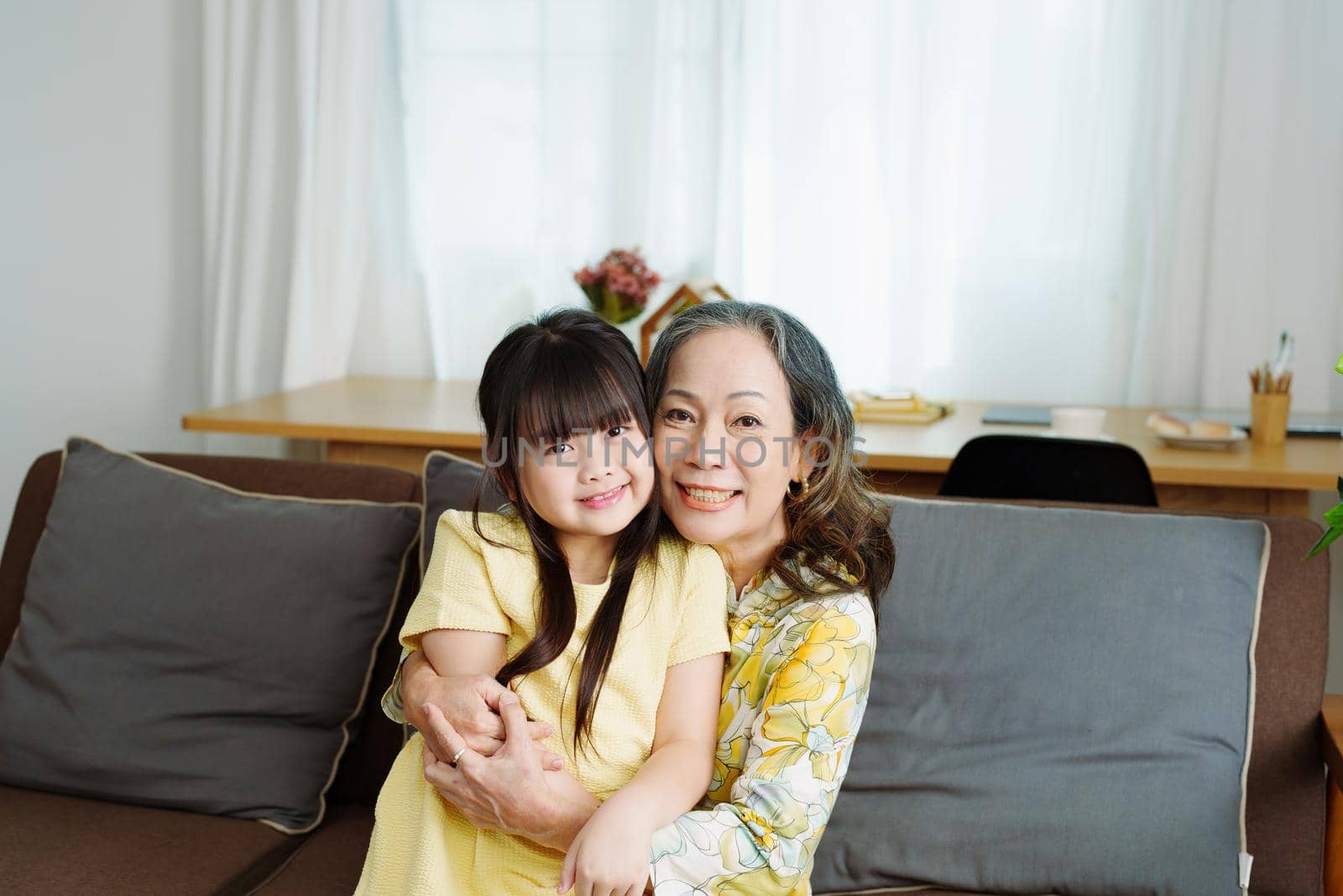 Asian portrait, grandma and granddaughter doing leisure activities and hugging to show their love and care for each other.