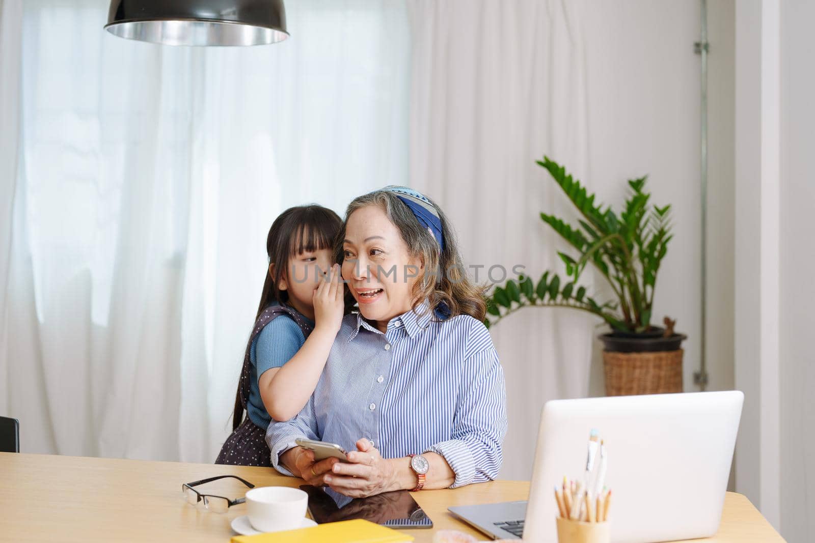 Asian portrait, grandmother and granddaughter doing leisure with little children whispering secrets between each other by Manastrong