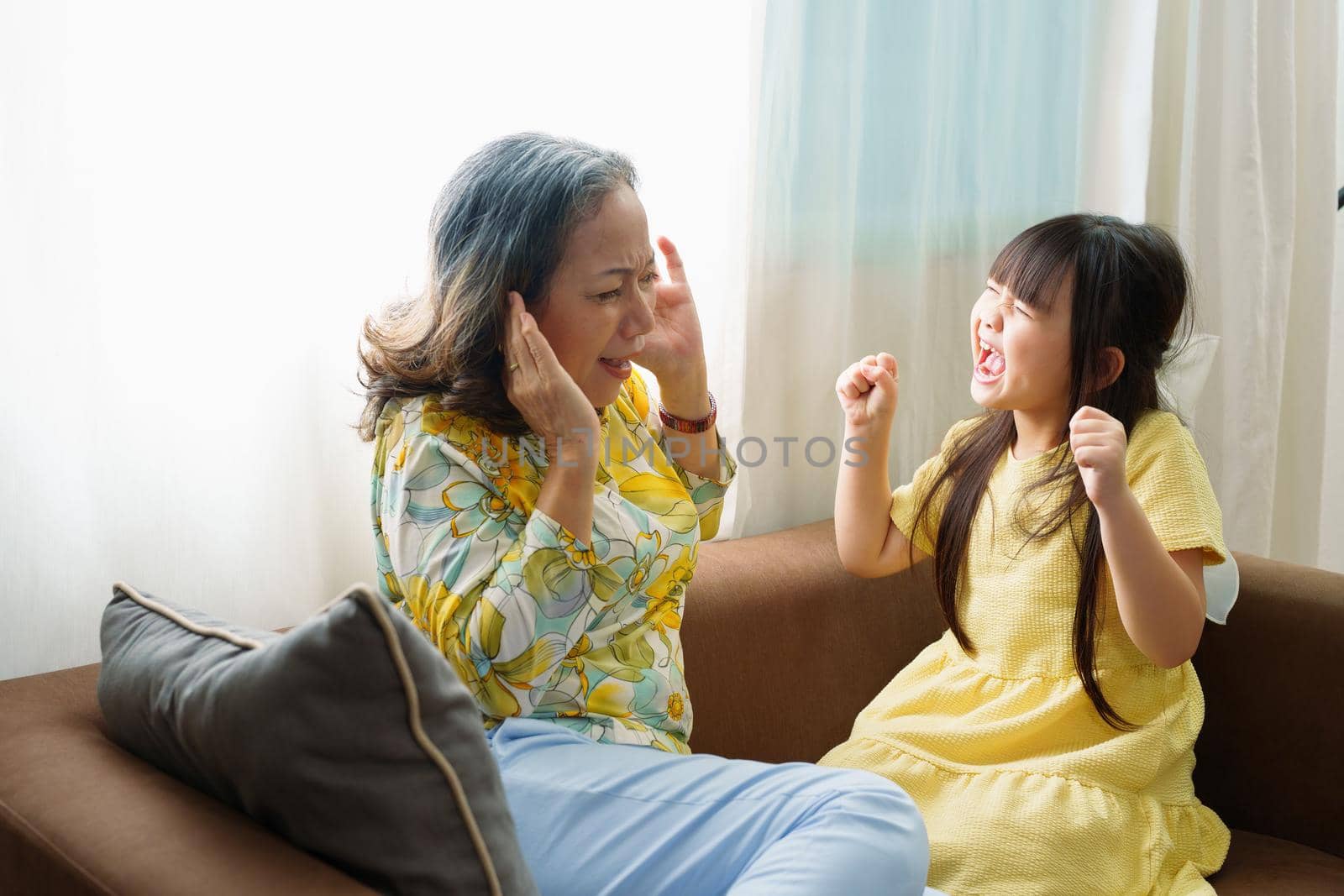 Asian portrait, granddaughter expressing displeasure by yelling at grandmother covering her ears, aggression, violence, upbringing by Manastrong