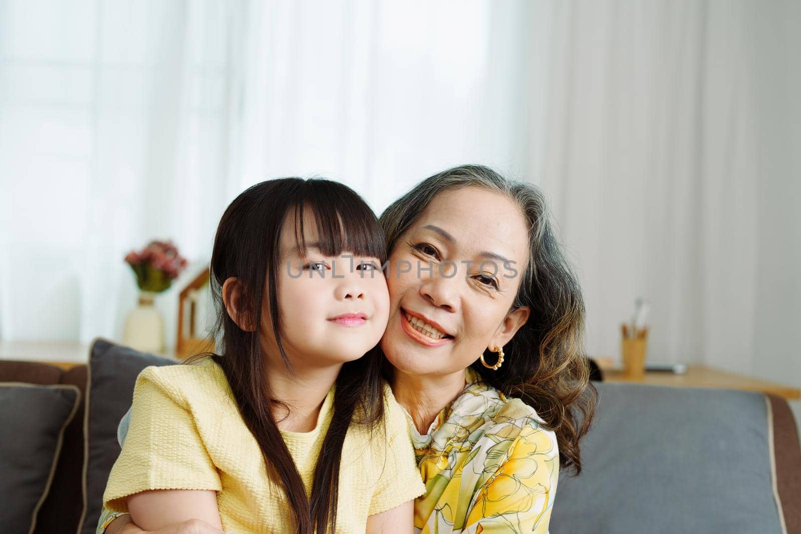 Asian portrait, grandma and granddaughter doing leisure activities and hugging to show their love and care for each other.