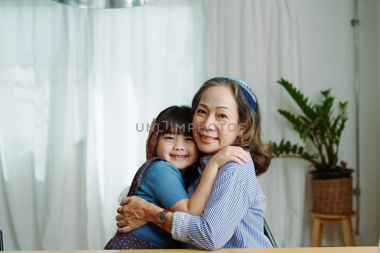 Asian portrait, grandma and granddaughter doing leisure activities and hugging to show their love and care for each other.