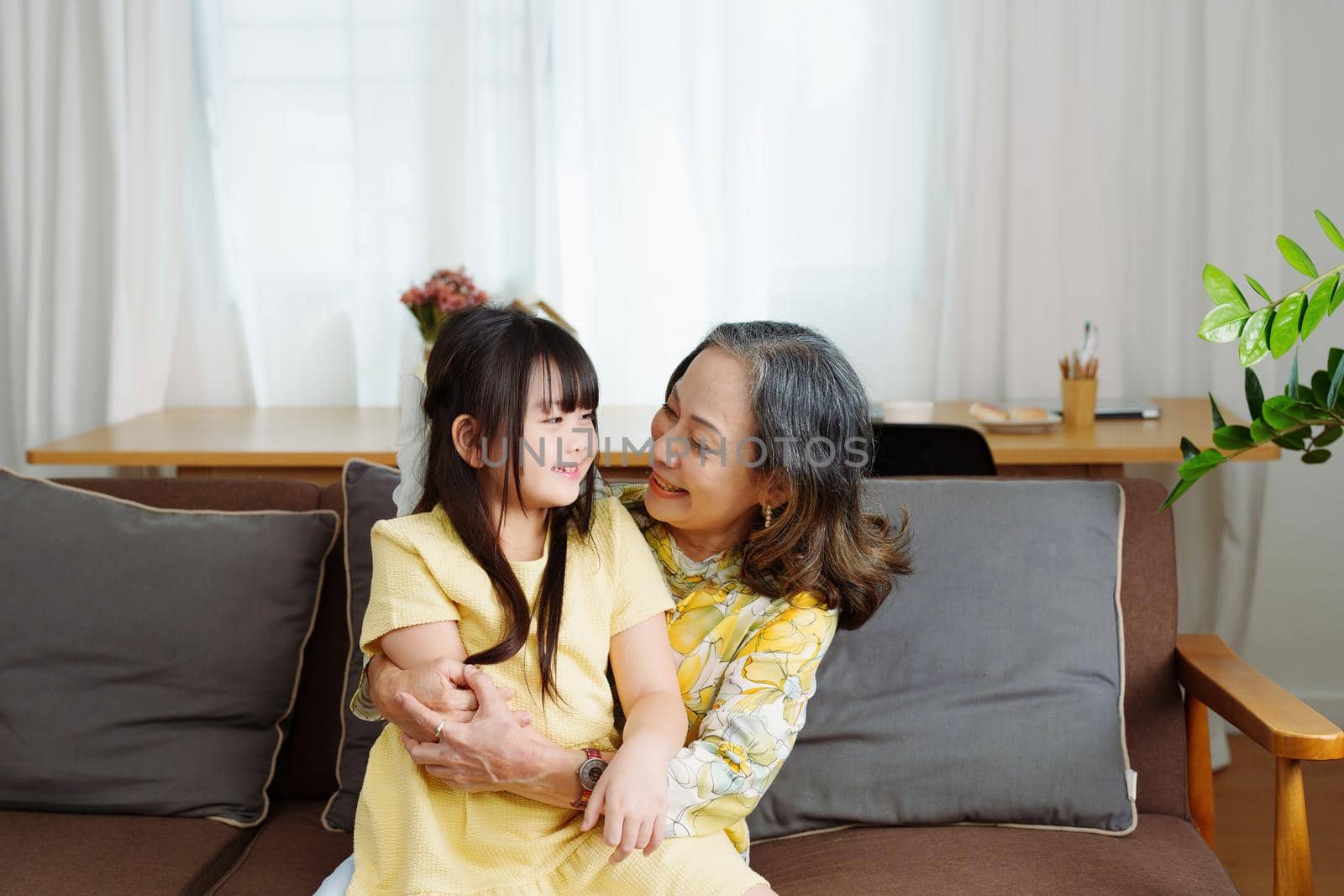 Asian portrait, grandma and granddaughter doing leisure activities and hugging to show their love and care for each other by Manastrong