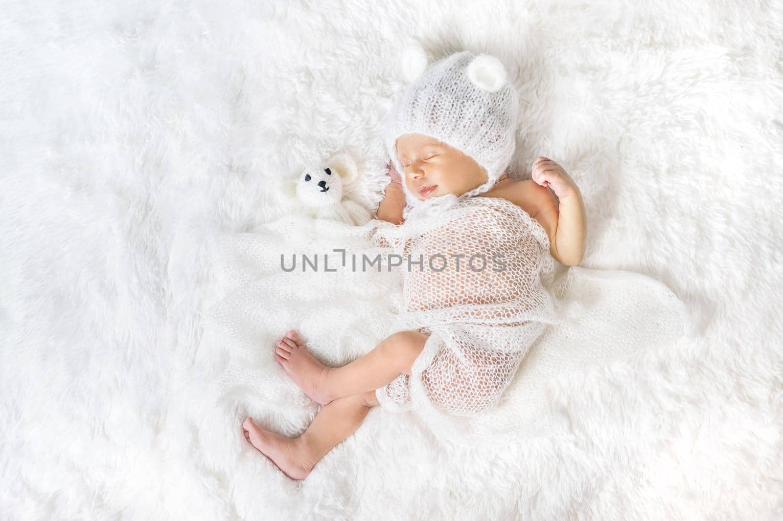 Newborn baby sleeps in a hat. Selective focus. by yanadjana