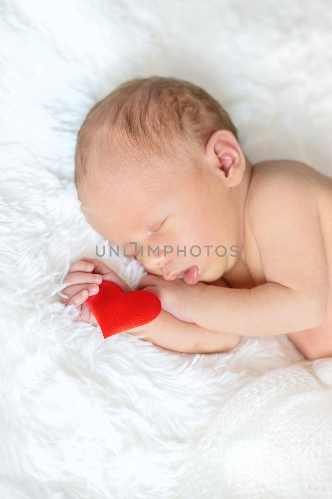 Newborn baby with heart in hand. Selective focus. people.