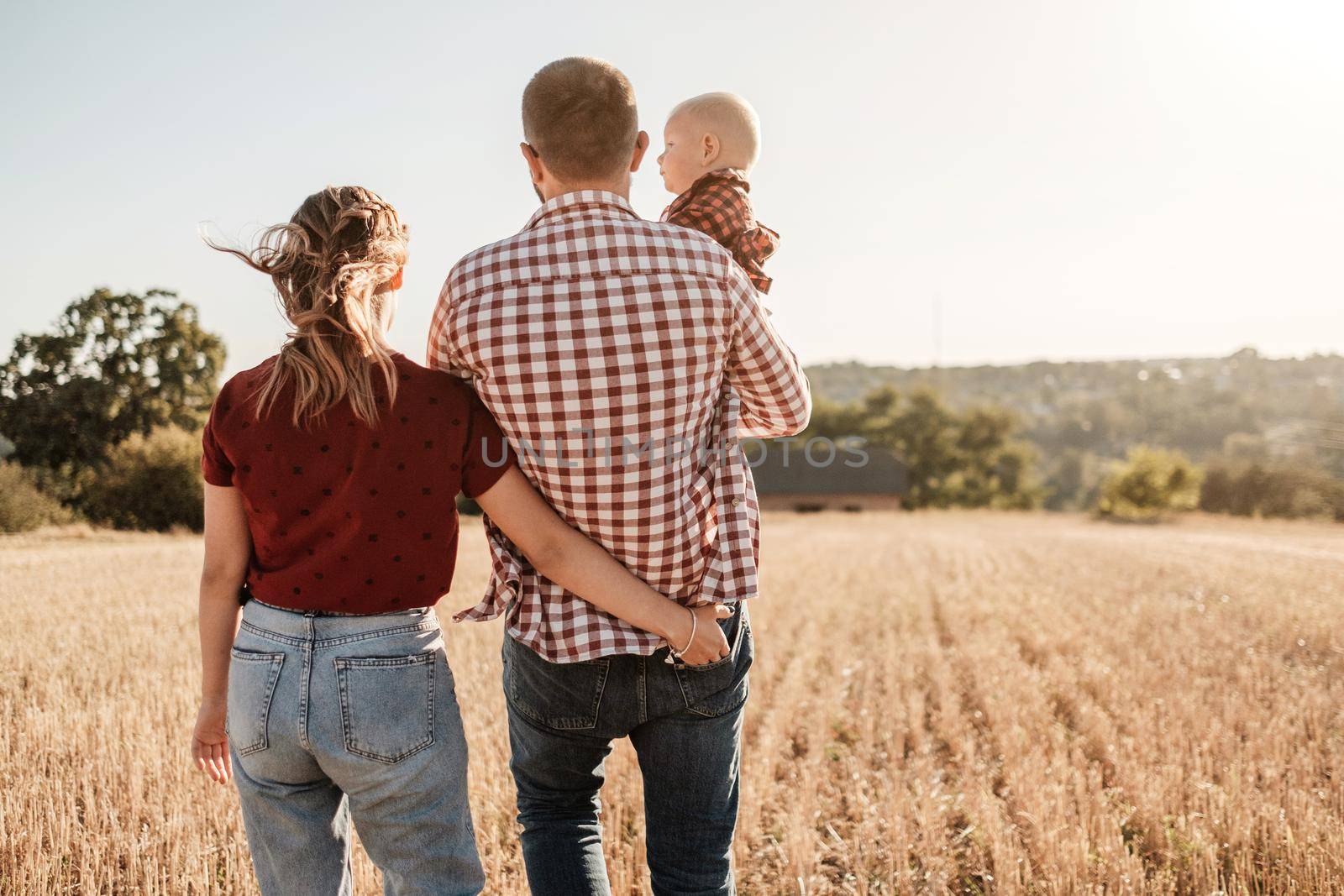 Happy Young Family Mom and Dad with Their Little Son Enjoying Summer Weekend Picnic Outside the City in Field at Sunny Day Sunset, Vacation Time Concept