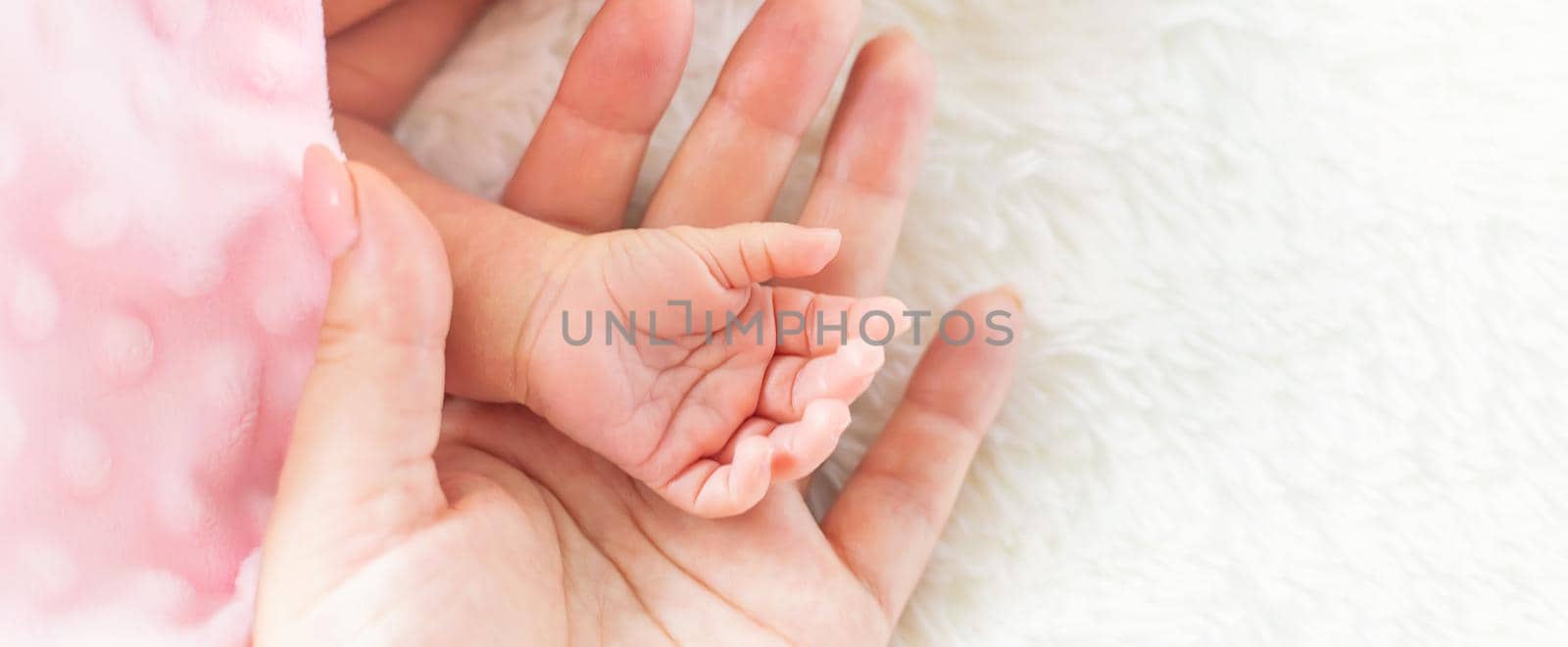 newborn baby is holding mother's hand. selective focus. people.