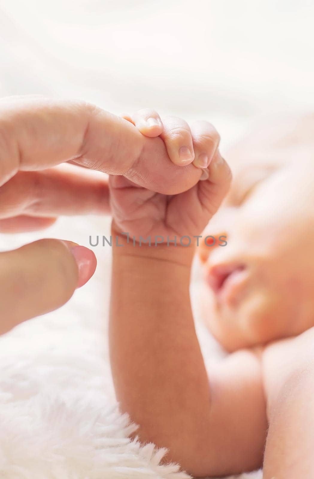 newborn baby is holding mother's hand. selective focus. by yanadjana