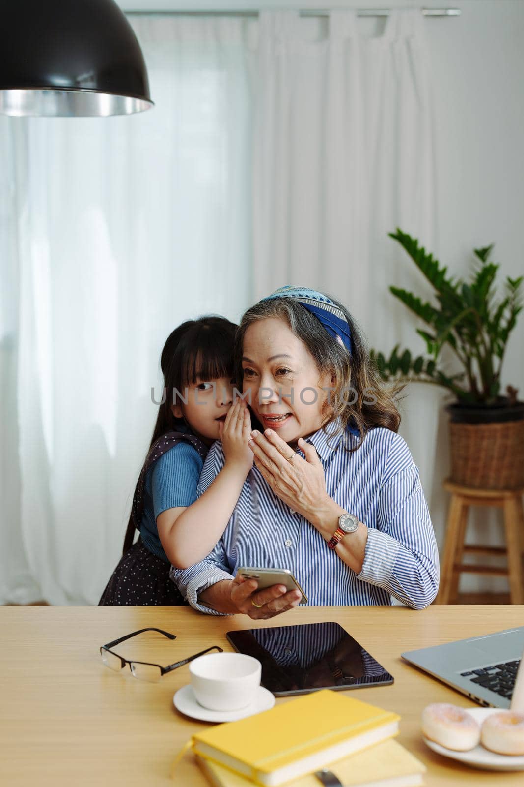 Asian portrait, grandmother and granddaughter doing leisure with little children whispering secrets between each other.