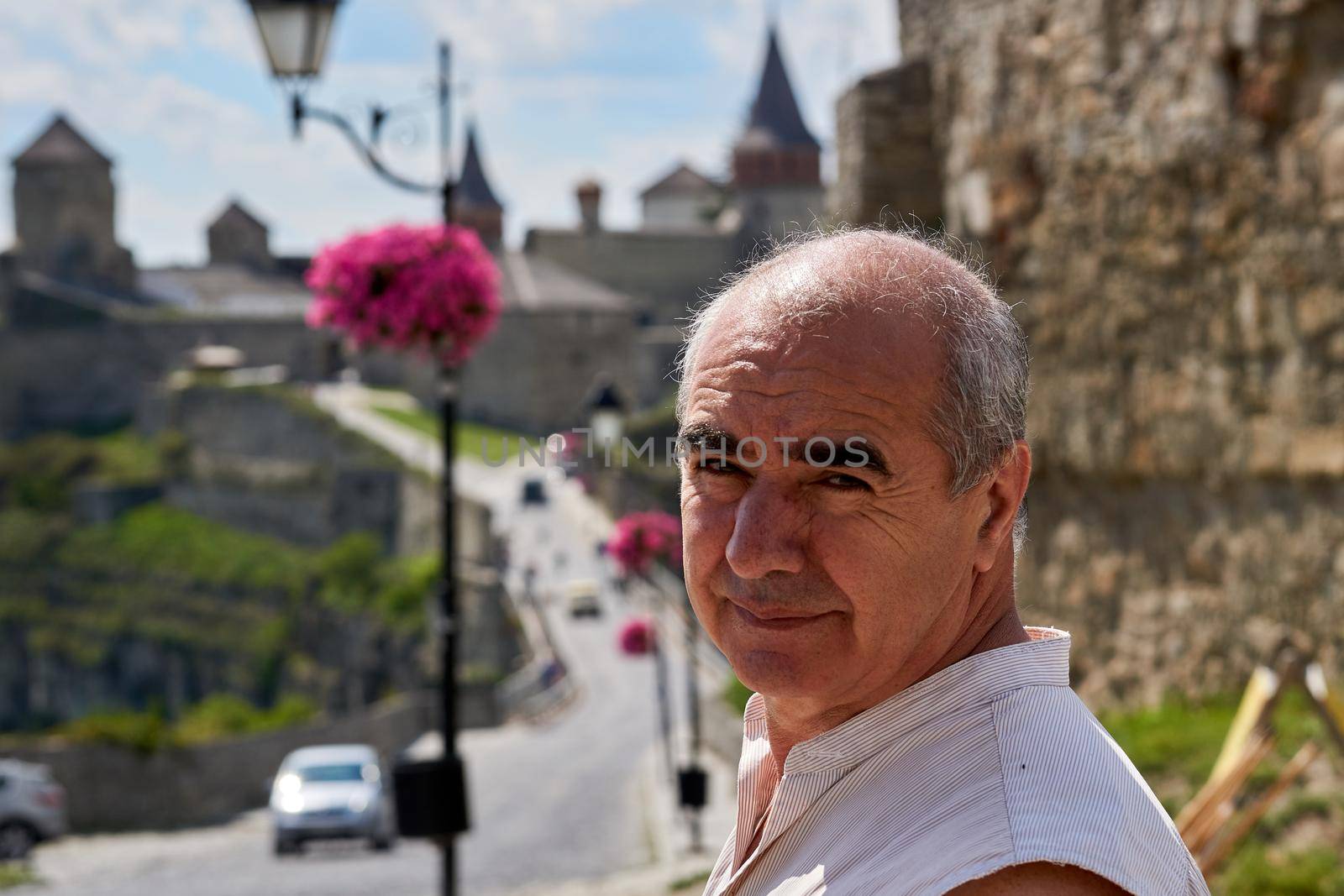 An elderly man pensioner tourist goes to see the sights of an ancient fortress by jovani68
