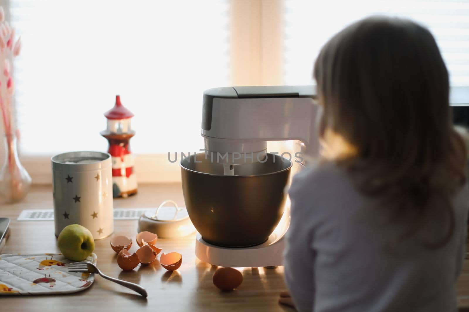 child looking at planetary mixer and baking pie in a cozy kitchen at home. High quality photo